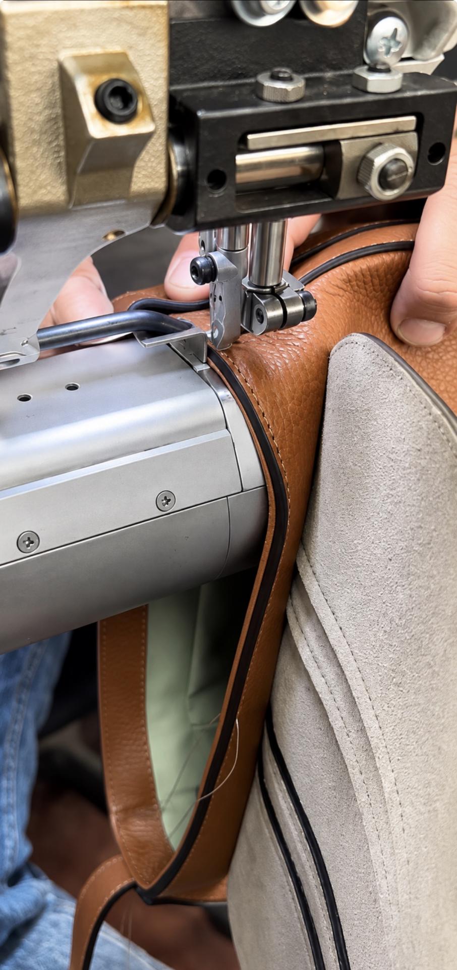 Screenshot Artigiano durante la cucitura di una borsa IOEF in pelle marrone, produzione Made in Italy in Toscana