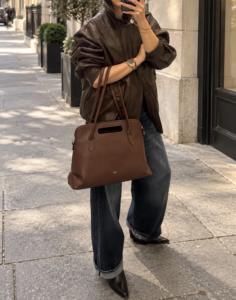 donna con borsa da lavoro IOEF in pelle martellata marrone, indossato con un look casual