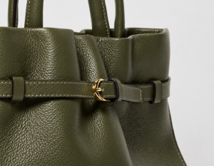 Dettaglio della pelle martellata verde oliva di una borsa IOEF, con grana evidente, cuciture e fibbia dorata.